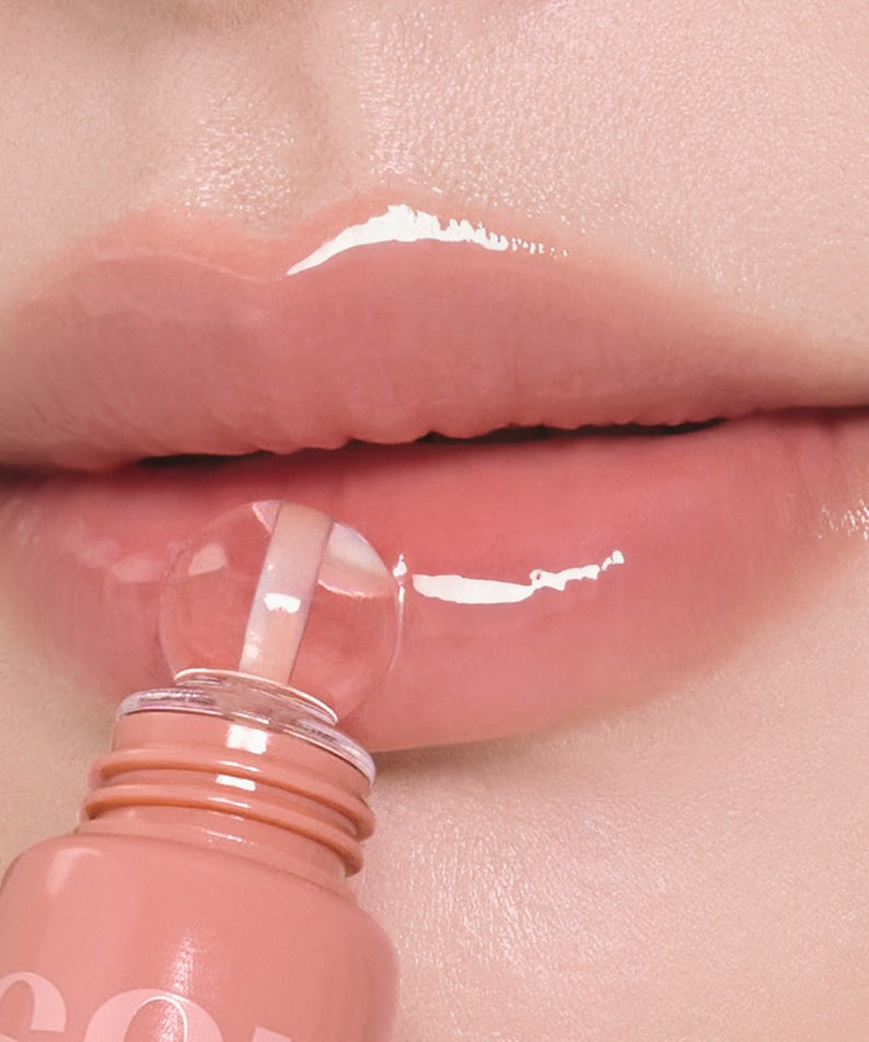 NUSE Nuzzle Reju Lip Gloss NUSE, gros plan sur des lèvres avec gloss brillant et flacon rose, contexte beauté.