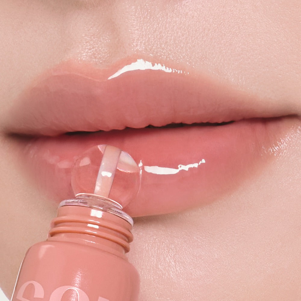 NUSE Nuzzle Reju Lip Gloss NUSE, gros plan sur des lèvres avec gloss brillant et flacon rose, contexte beauté.