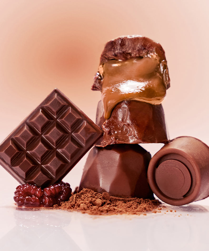 NUSE Nuzzle Reju Lip Gloss : gloss brun brillant sur fond rose, tablette chocolat et poudre, branding NUSE, vue produit.