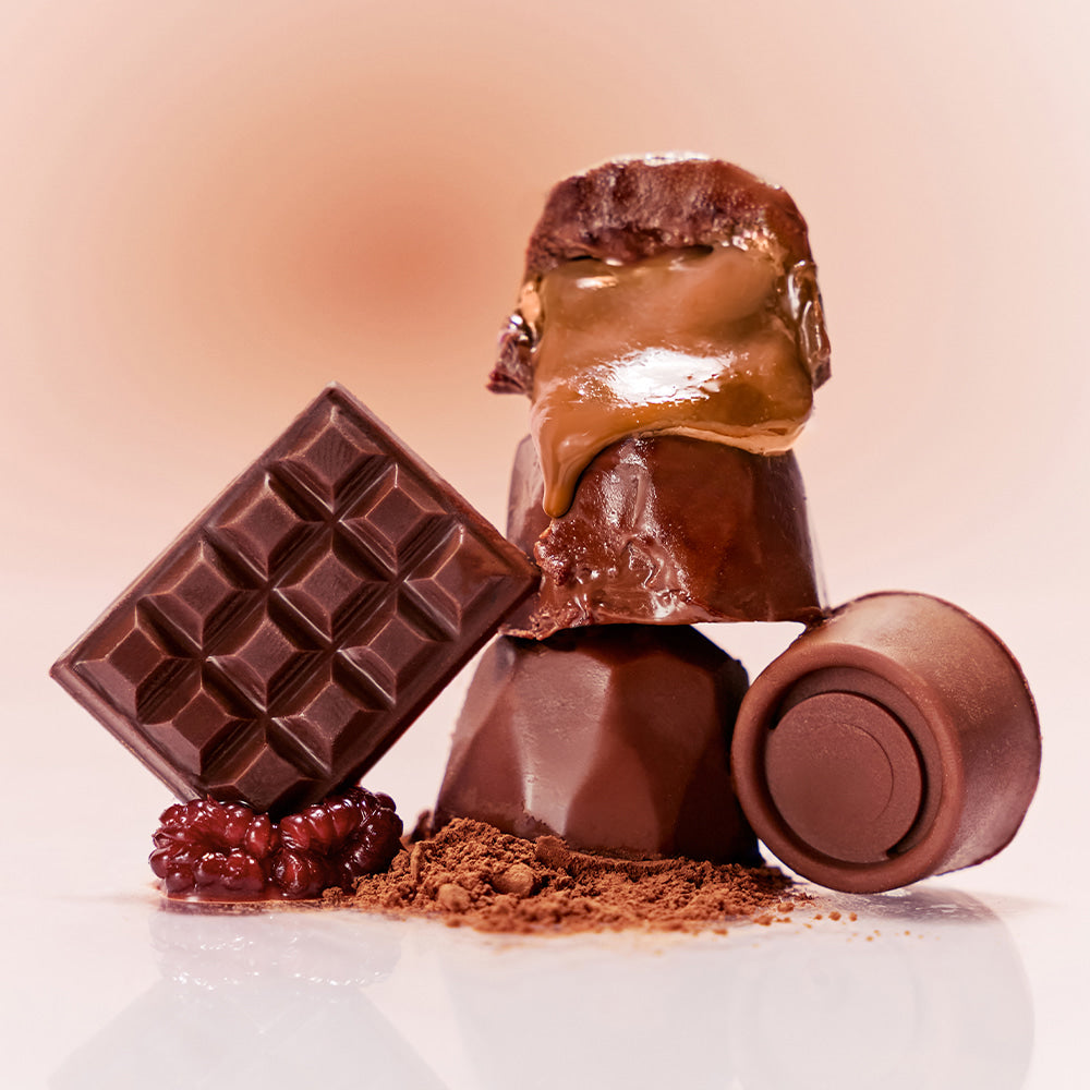 NUSE Nuzzle Reju Lip Gloss : gloss brun brillant sur fond rose, tablette chocolat et poudre, branding NUSE, vue produit.