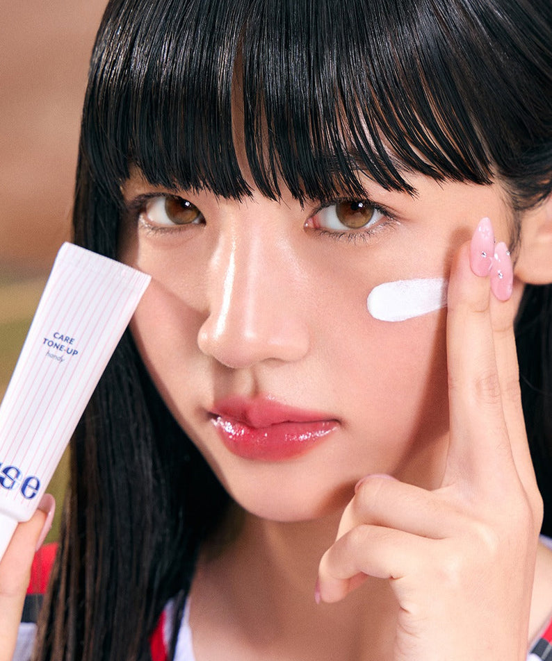 Femme appliquant la crème NUSE X Landers Care Tone Up Handy sur sa joue, idéale pour un teint éclatant.