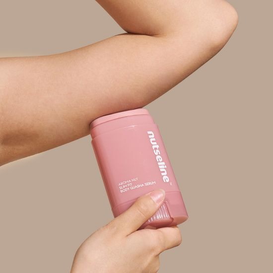 NUTSELINE Aroma Nut Slim Fit Body Guasha Serum 60ml de la marque NUTSELINE, flacon rose sur bras en massage guasha