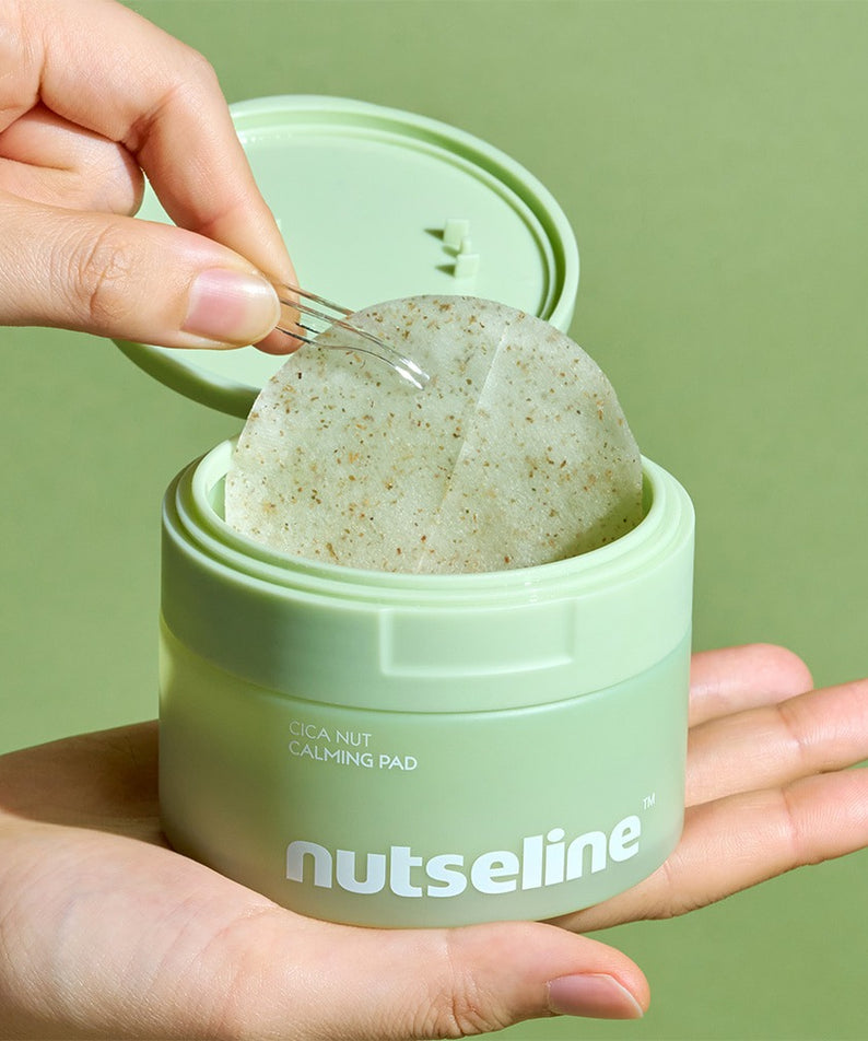 Main ouvre NUTSELINE Cica Calming Pad, coussin apaisant cica dans un pot vert sur fond vert, marque NUTSELINE