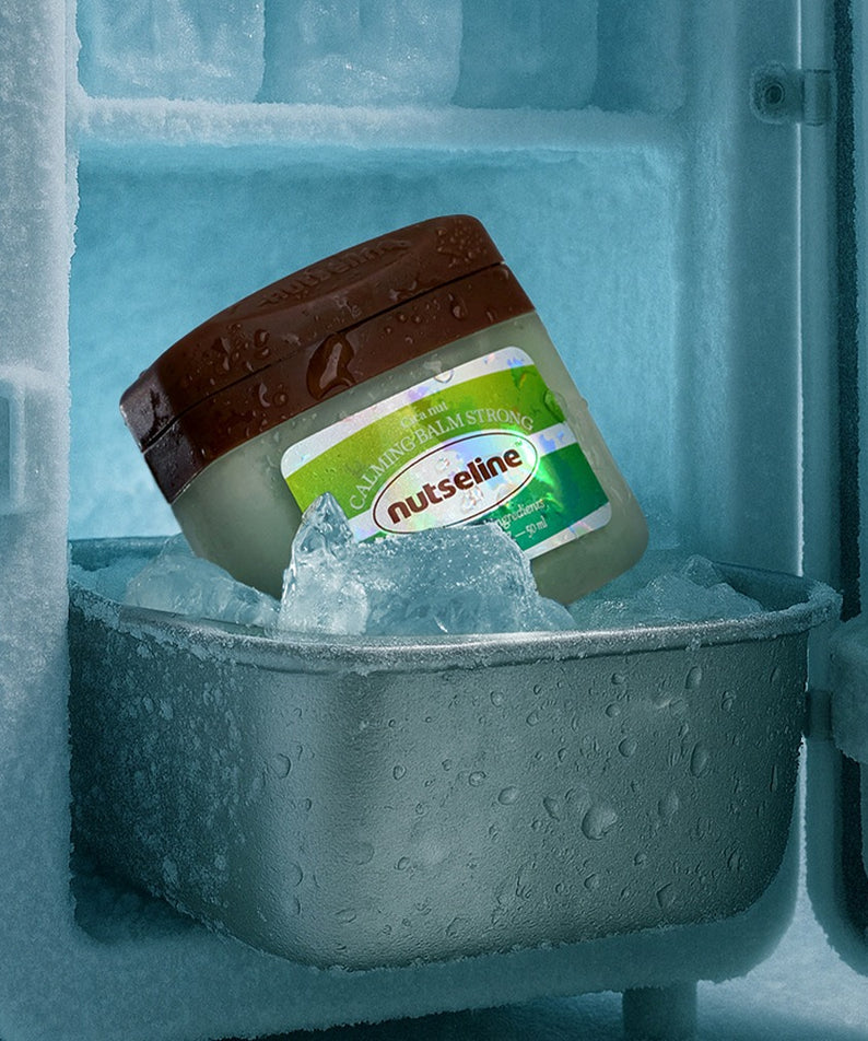 NUTSELINE Cica Nut Calming Balm Strong 50ml de NUTSELINE, baume apaisant sur glace/compartiment froid, contexte visuel bleu.
