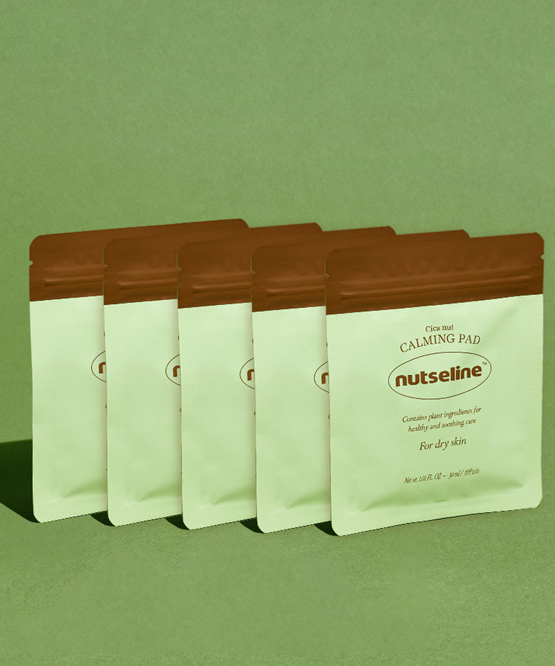 Six paquets de NUTSELINE Cica Nut Calming Pads posés sur un fond vert.