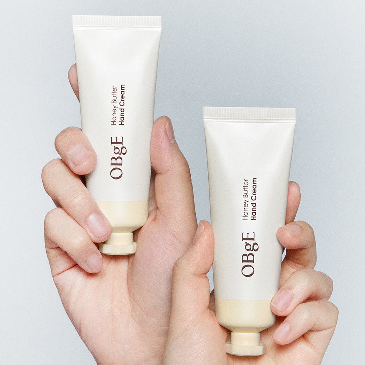 OBGE Honey Butter Hand Cream 50ml, crème mains OBGE au miel, présentation sur mains contre fond clair.