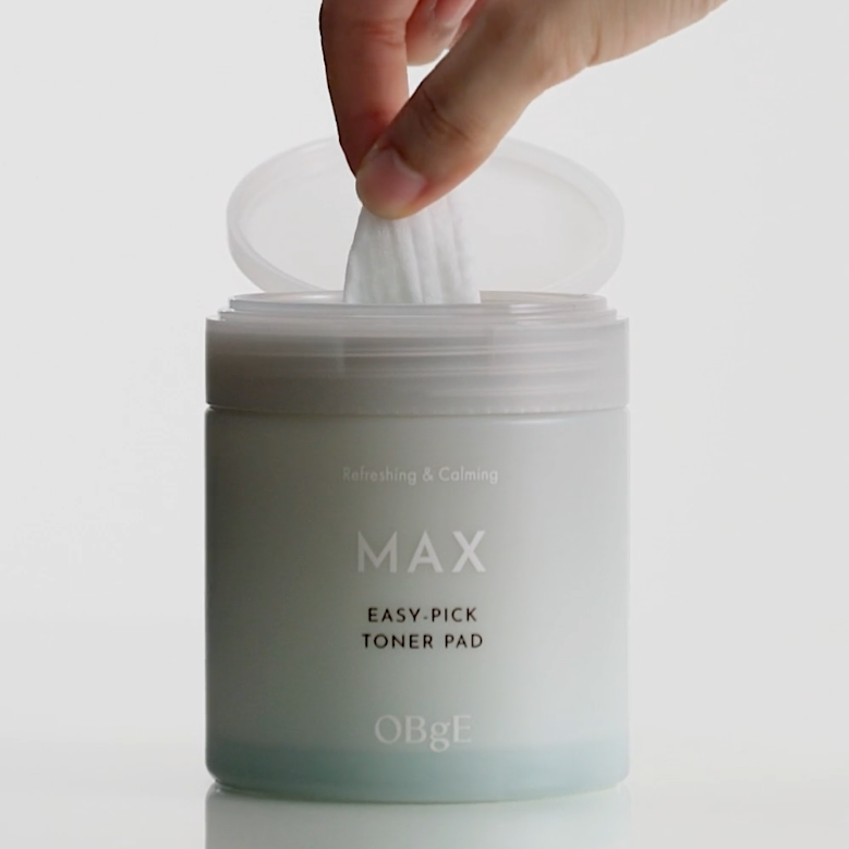 OBGE Max Easy Pick Toner Pad 250ml, marque OBGE : main prélève une lingette tonique sur fond blanc.