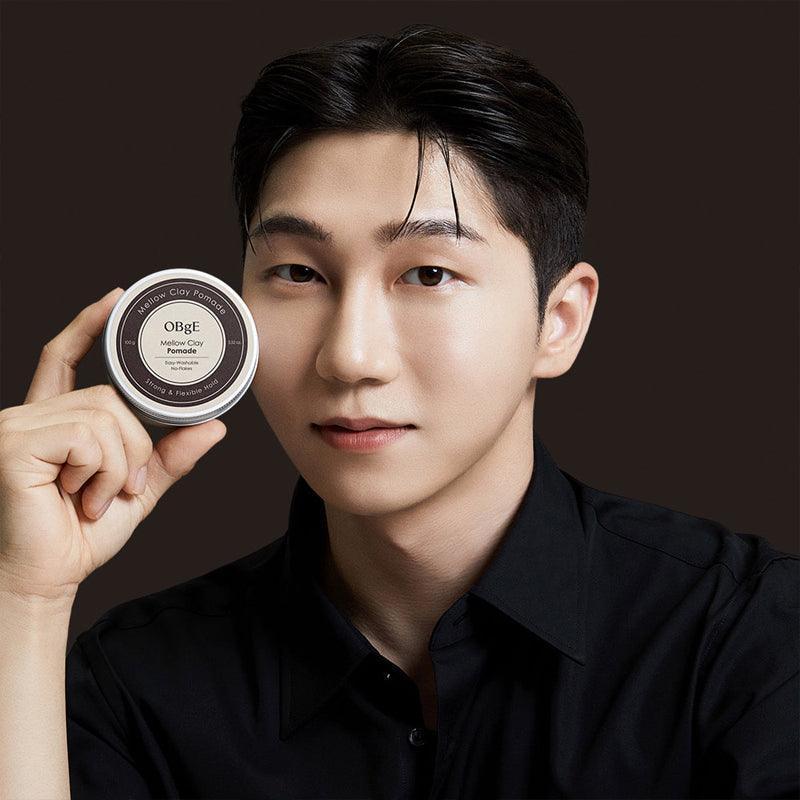 OBGE Mellow Clay Pomade 100g : pot de cire pour cheveux OBGE, homme avec look coiffé sur fond sombre.