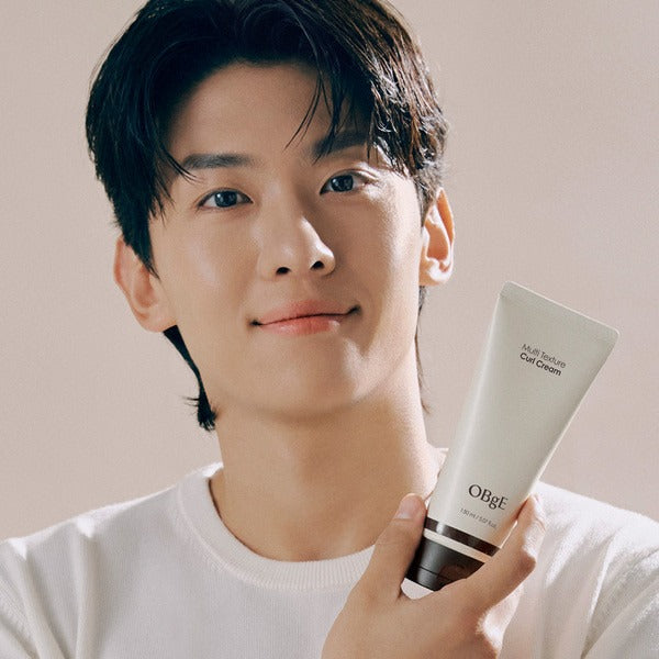 OBGE Multi-texture curl cream 150ml de la marque OBGE, tube tenu près du visage, homme aux cheveux bouclés.