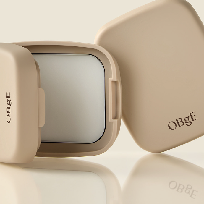 Décris l'image en français : OBGE Oil Control Finisher de la marque OBGE, flacons crème beige sur fond clair.