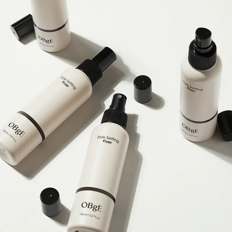 Décris l’image en français : OBGE Style Setting Fixer 150ml, bouteilles de marque OBGE sur fond clair, style capillaire.