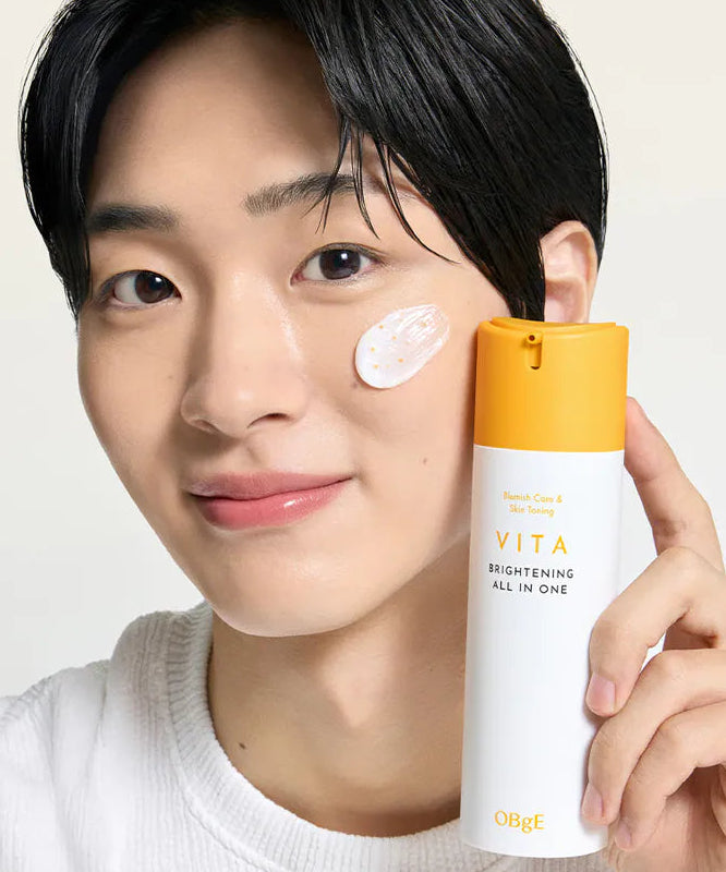 Décris l'image en français : OBGE Vita Brightening All-in-One 150ml ObGé, homme pose crème, produit sur fond clair.