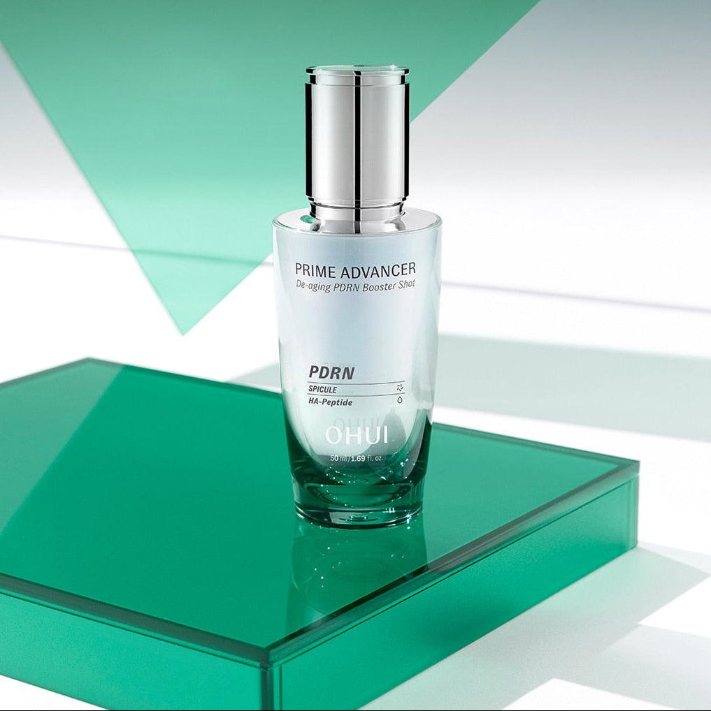 OHUI  Prime Advancer De-Aging PDRN Booster Shot 50ml, flacon sur socle vert, décor géométrique, style soin anti-âge