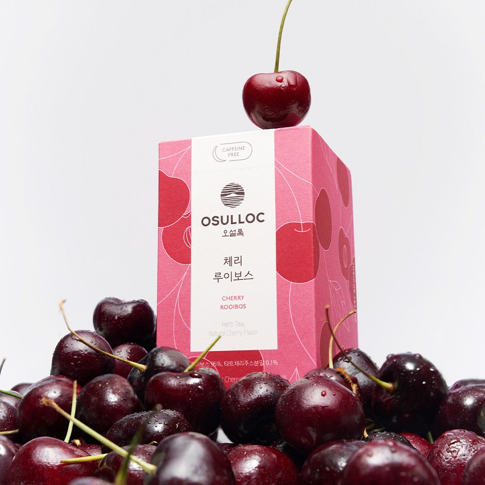 OSULLOC [Caffeine-Free] Cherry Rooibos : sachet OSULLOC et cerises fraîches sur fond clair, ambiance naturelle.