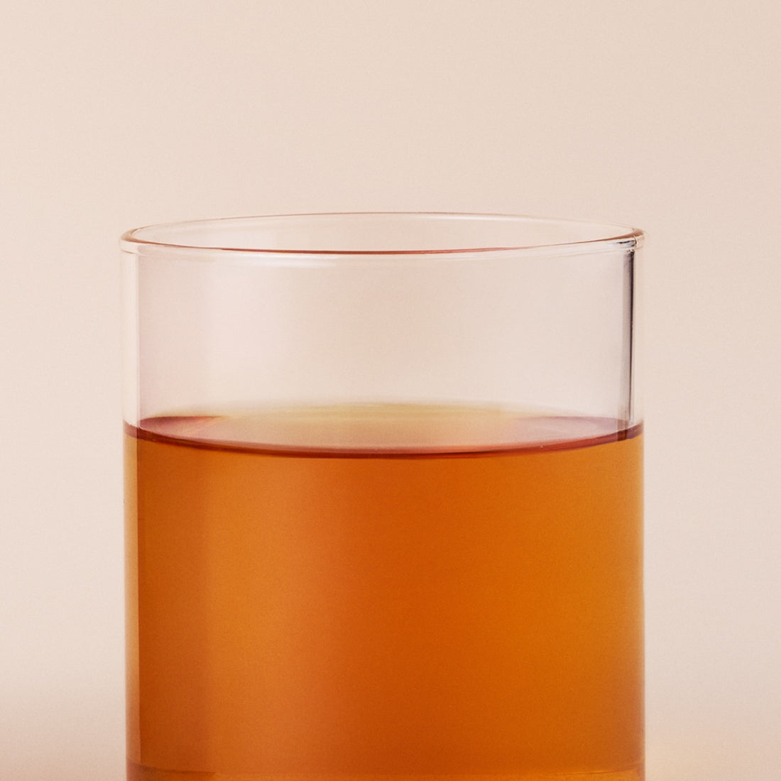 OSULLOC Fig Chocolate Black Tea 20 P : infusion ambrée en verre, arrière-plan beige, ambiance dégustation.