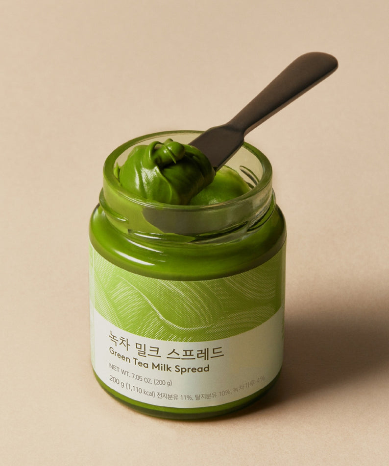OSULLOC Green Tea Milk Spread 200g : pot vert en verre avec cuillère, style thé matcha, sur fond clair.