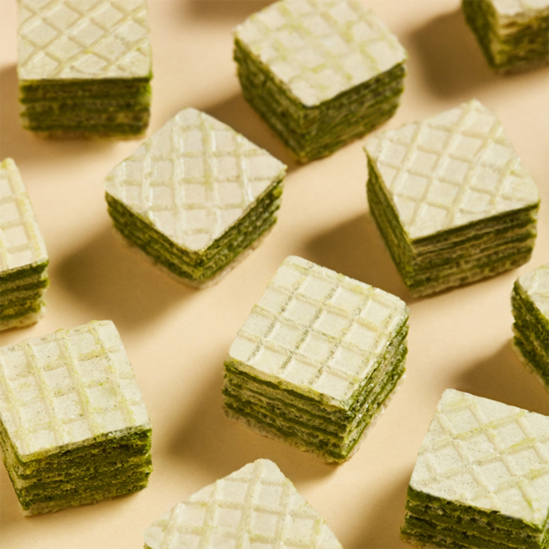 OSULLOC Green Tea Wafers 100g : gaufrettes vert thé matcha de la marque OSULLOC, sur fond beige, gros plan.