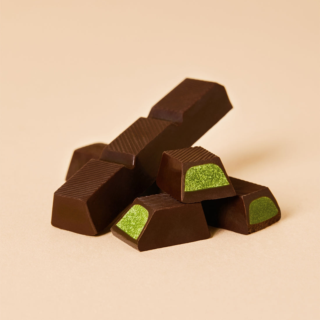 OSULLOC Jeju Island Green Tea Chocolate Bar 120g : morceaux de chocolat au thé vert, fond beige, ambiance produit.