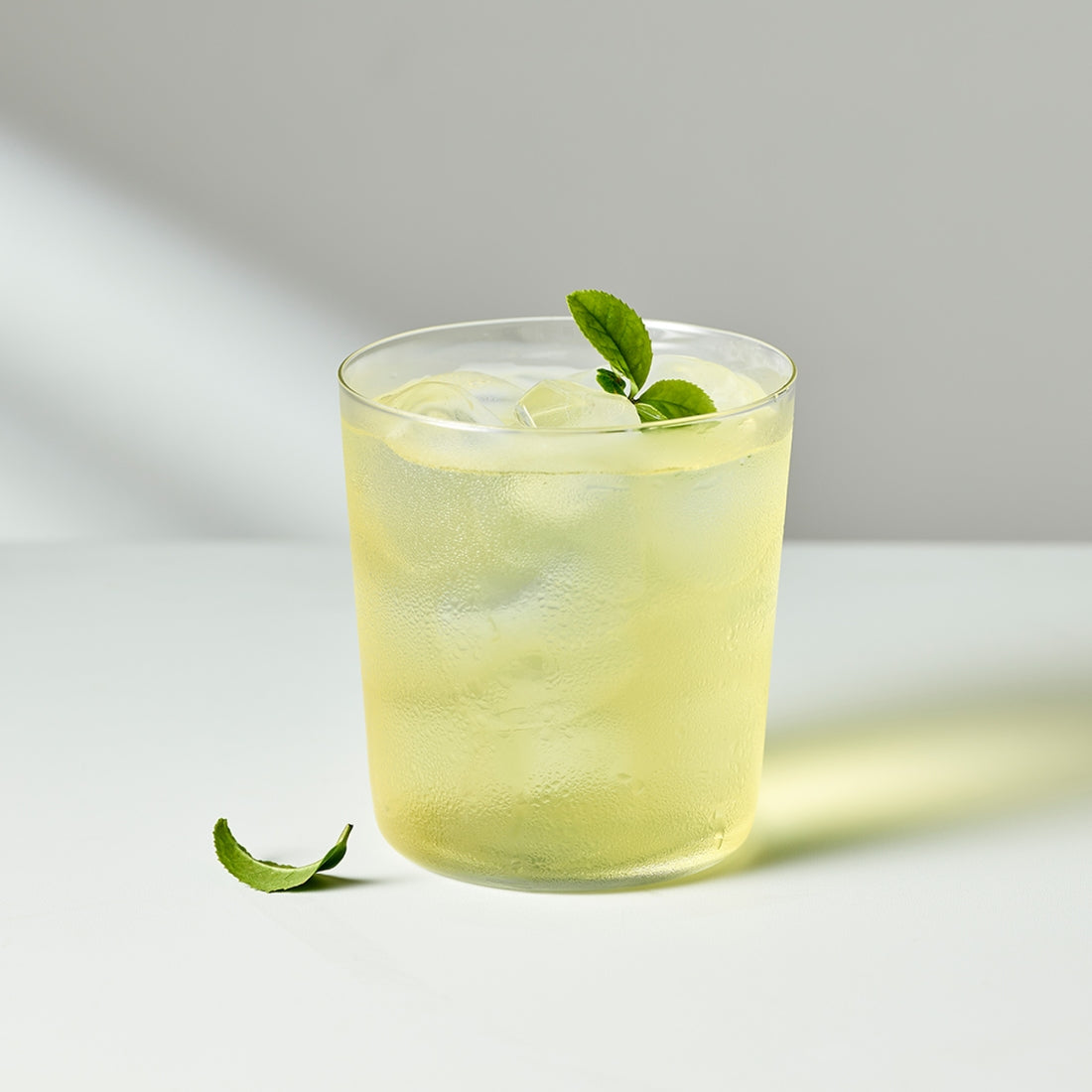 OSULLOC Jeju Pure Green Tea 20 P : boisson au thé vert, citron et feuilles, fond clair, marque OSULLOC