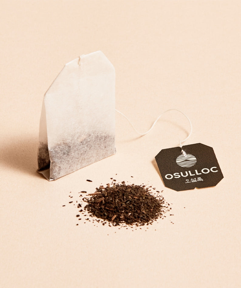 Décris l'image : OSULLOC Jeju Volcanic Oolong Tea 20 P, sachets étiquetés et feuilles de thé sur fond clair.