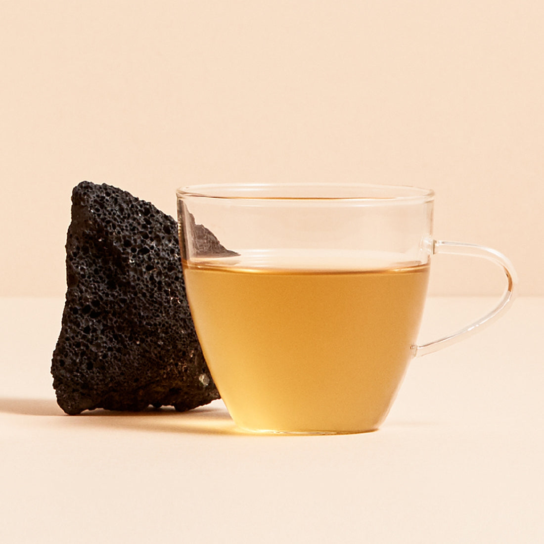 OSULLOC Jeju Volcanic Oolong Tea 20 P, tasse de thé oolong sur fond beige, roche volcanique en décor (marque OSULLOC).