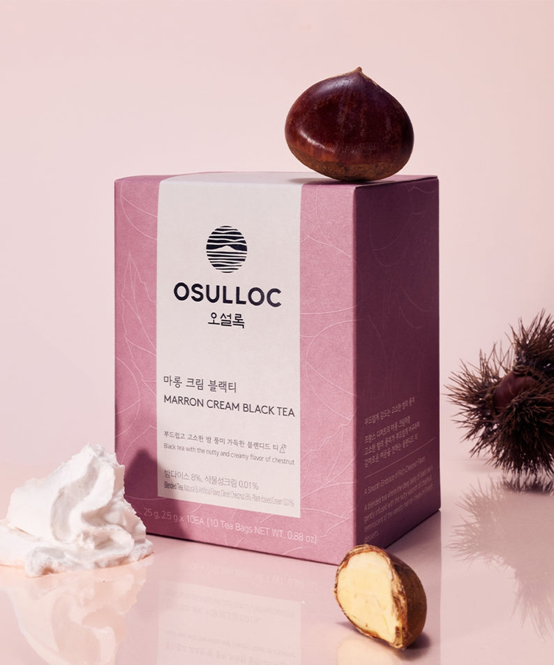 Décris l'image en français : OSULLOC Marron Cream Black Tea 10 p., coffret et marron, fond rose, décor crème.