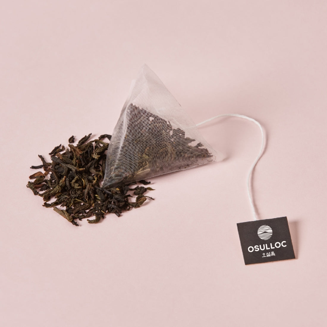 OSULLOC Milky Oolong Tea 10 p, sachet et feuilles infusées, marque OSULLOC sur fond rose, style minimaliste.