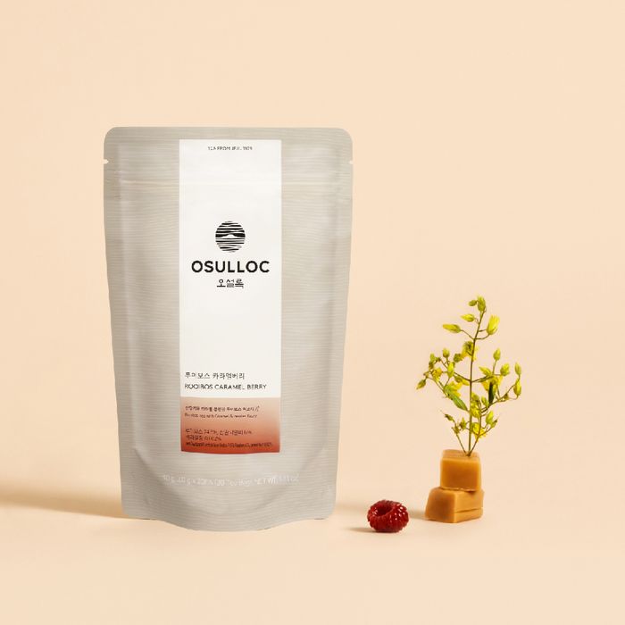 OSULLOC Rooibos Caramel Berry Tea 20p, sachet sur fond clair beige avec baies et petite plante, style produit.