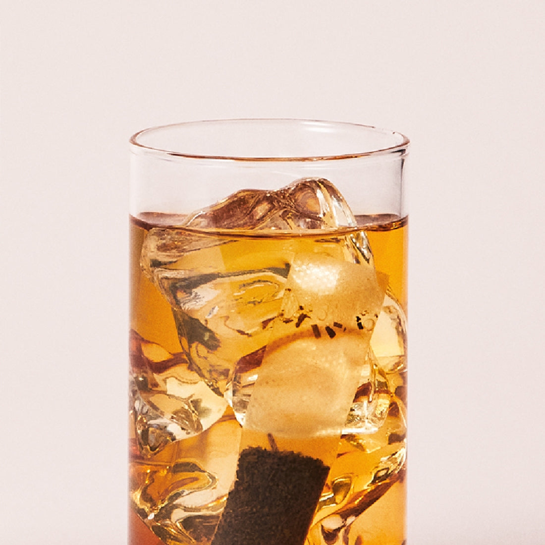OSULLOC Sunset Peach Cold Brew Tea 20 P : boisson glacée aux glaçons, teinte pêche, fond clair, vue rapprochée.