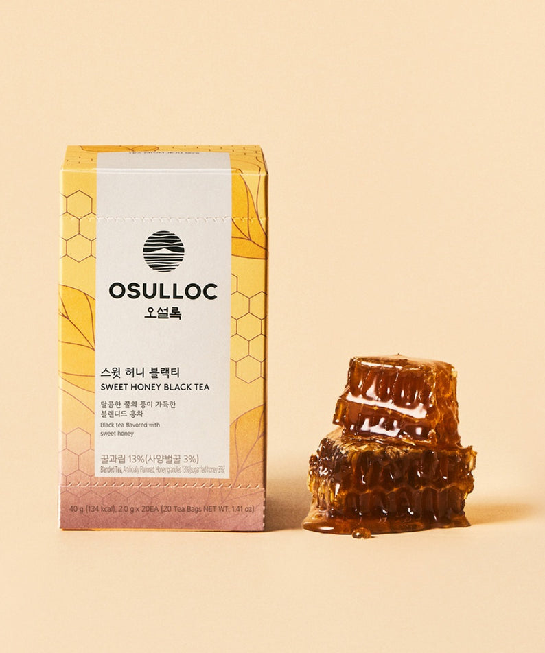 OSULLOC Sweet Honey Black Tea 20 P : boîte et sachets de thé posés sur fond beige, avec gouttes de miel visuelles.