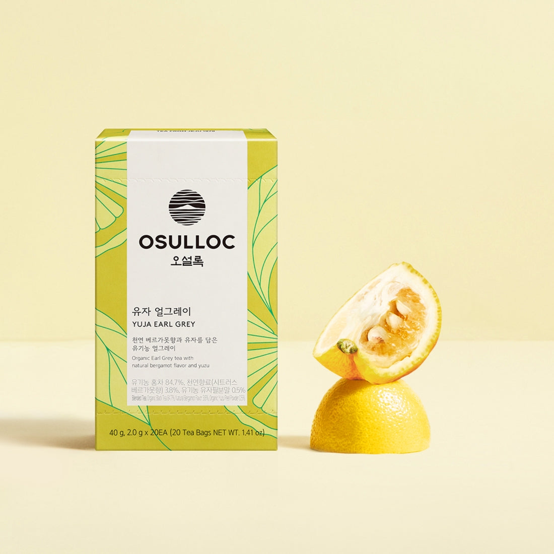 OSULLOC Yuja Earl Grey 20 p : boîte et agrume yuja, décor studio beige, feuille verte, thé Earl Grey prêt à infuser.