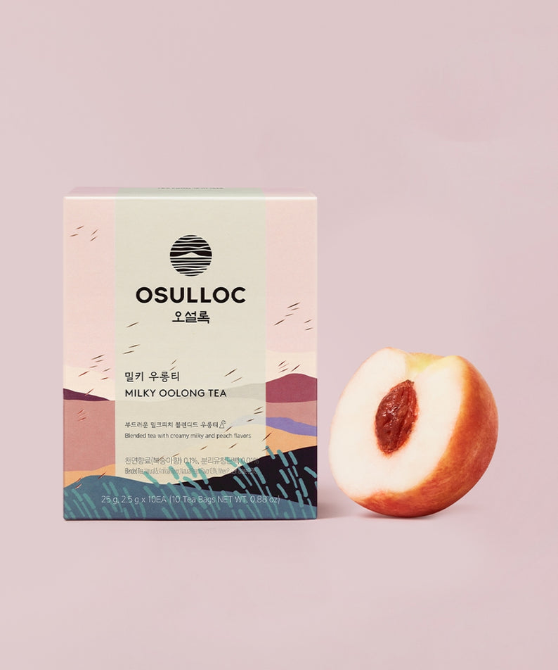 Boîte de thé OSULLOC Milky Oolong Tea 10 p avec pêche en arrière-plan. Thé délicat et authentique pour les amateurs de thé.
