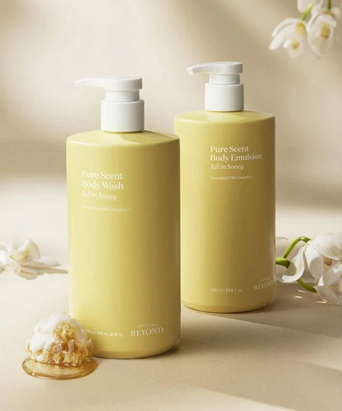 Flacons de PASSON&BEYOND Pure Scent Full-in-Honey Boday Wash 700g avec fleurs blanches et miel en fond élégant.