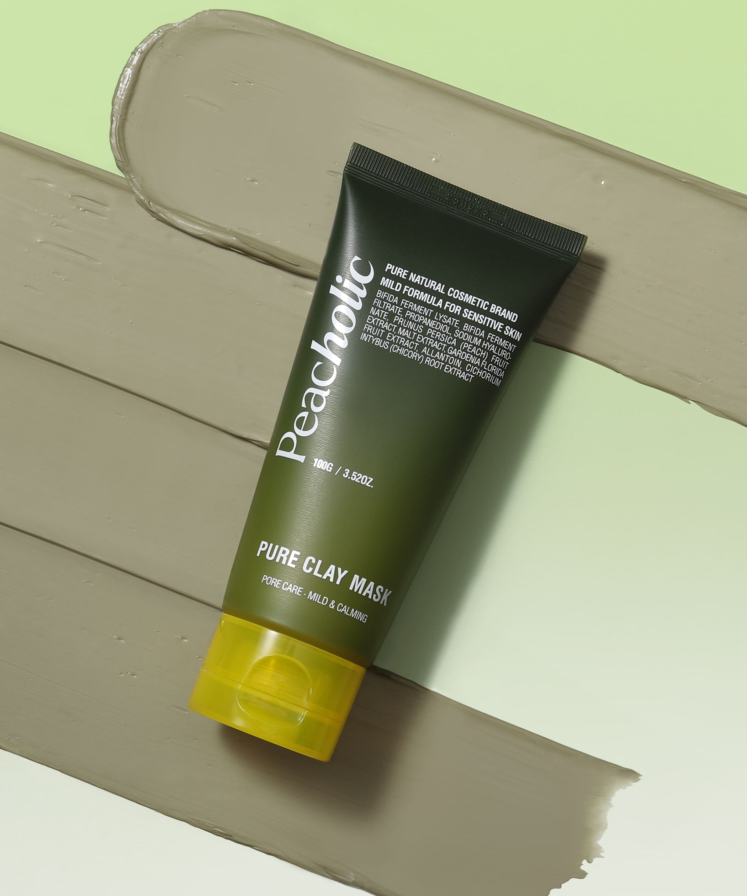 Décris l'image en français : PEACHOLIC  Pure Clay Mask 100ml, tube de masque en argile verte sur fond pastel