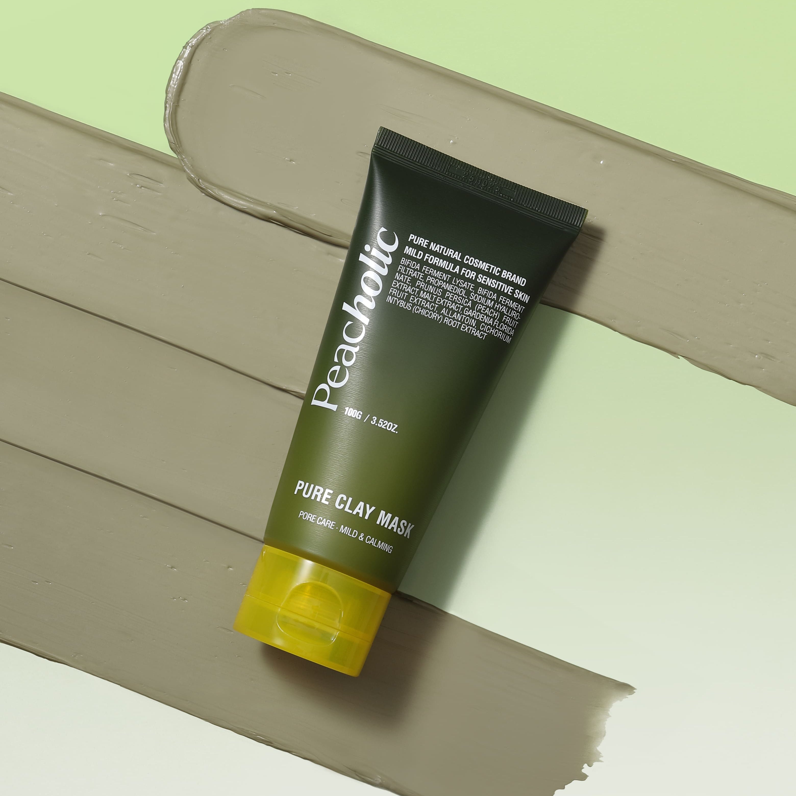 Décris l'image en français : PEACHOLIC  Pure Clay Mask 100ml, tube de masque en argile verte sur fond pastel