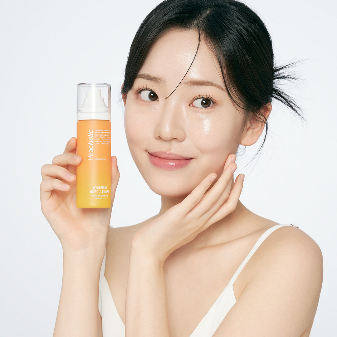 PEACHOLIC  Whitening Ampoule Mist 100ml : femme tenant le flacon sur fond clair, marque PEACHOLIC en évidence.