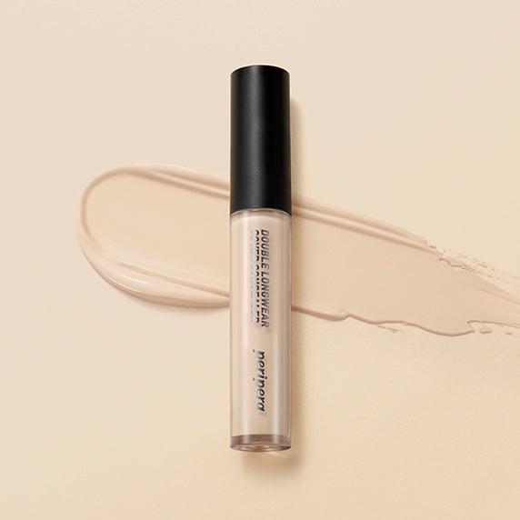 PERIPERA Double Longwear Cover Concealer de la marque PERIPERA, tube maquillage sur fond nude, texture liquide étalée