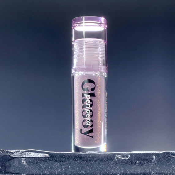 PERIPERA Ink Glazing Lip Gloss Plumper, flacon brillant violet sur fond bleu, mise en scène maquillage.