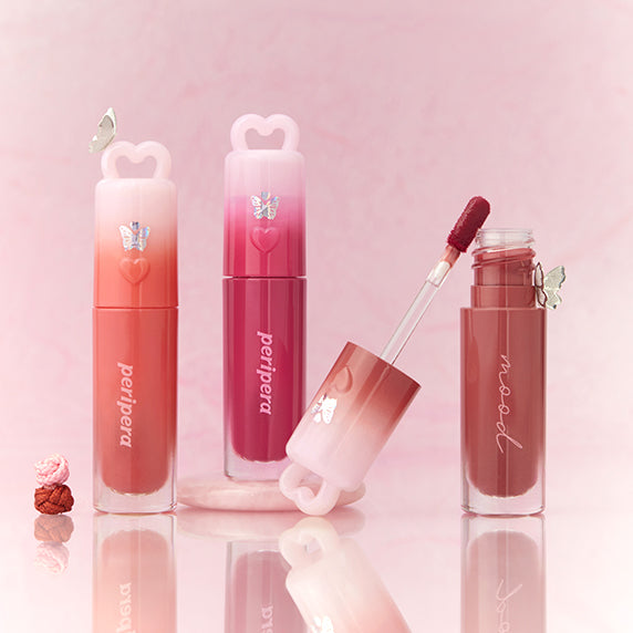 PERIPERA Ink Mood Glowy Tint : baume teinté rose, flacons alignés sur fond pastel, ambiance maquillage