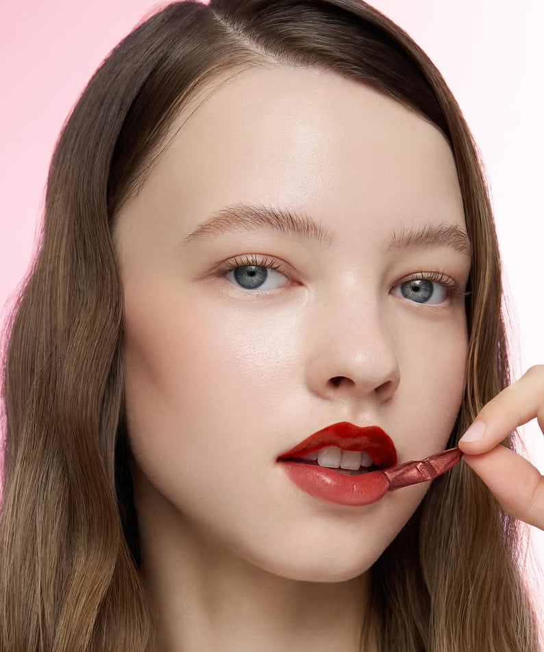 PERIPERA Ink Peel-Off Lip Stain, marque PERIPERA : pose maquillage lèvres rouges, main appliquant l’ink, fond rose