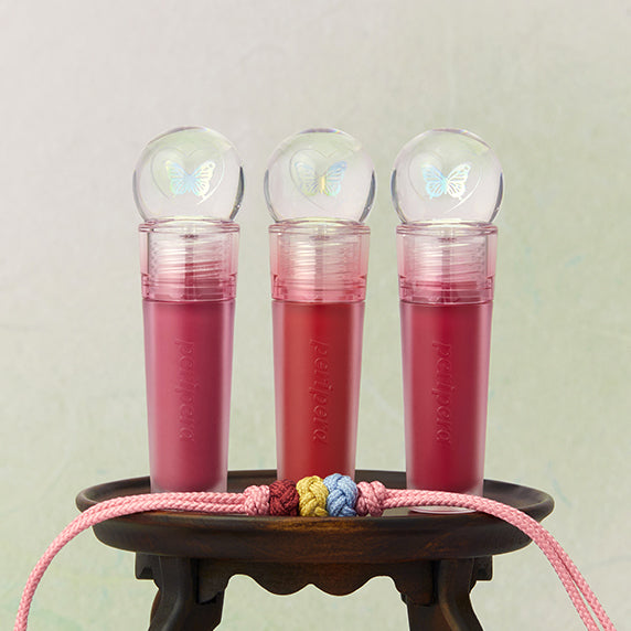 PERIPERA Ink The Gellable Tint, tints liquides roses dans de petits flacons sous dôme, arrière-plan pastel.