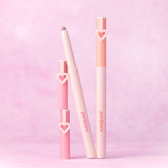 Décris l'image en français : PERIPERA Mood in Shade Eye Stick sur fond rose, marque PERIPERA, packaging cœur, maquillage yeux.