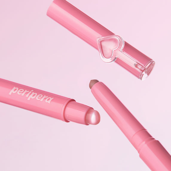 PERIPERA Puppy Plumping Dew Lip Pencil, tube et embout cœur sur fond rose pastel, produit cosmétique en gros plan