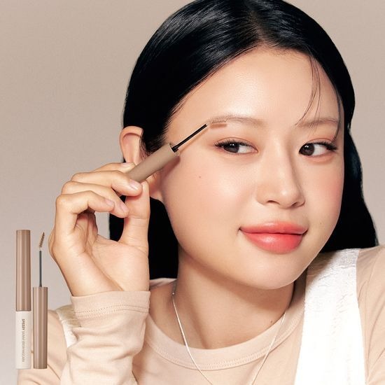 PERIPERA Speedy Skinny Brow Mascara de la marque PERIPERA, maquillage des sourcils sur fond beige, modèle en gros plan.