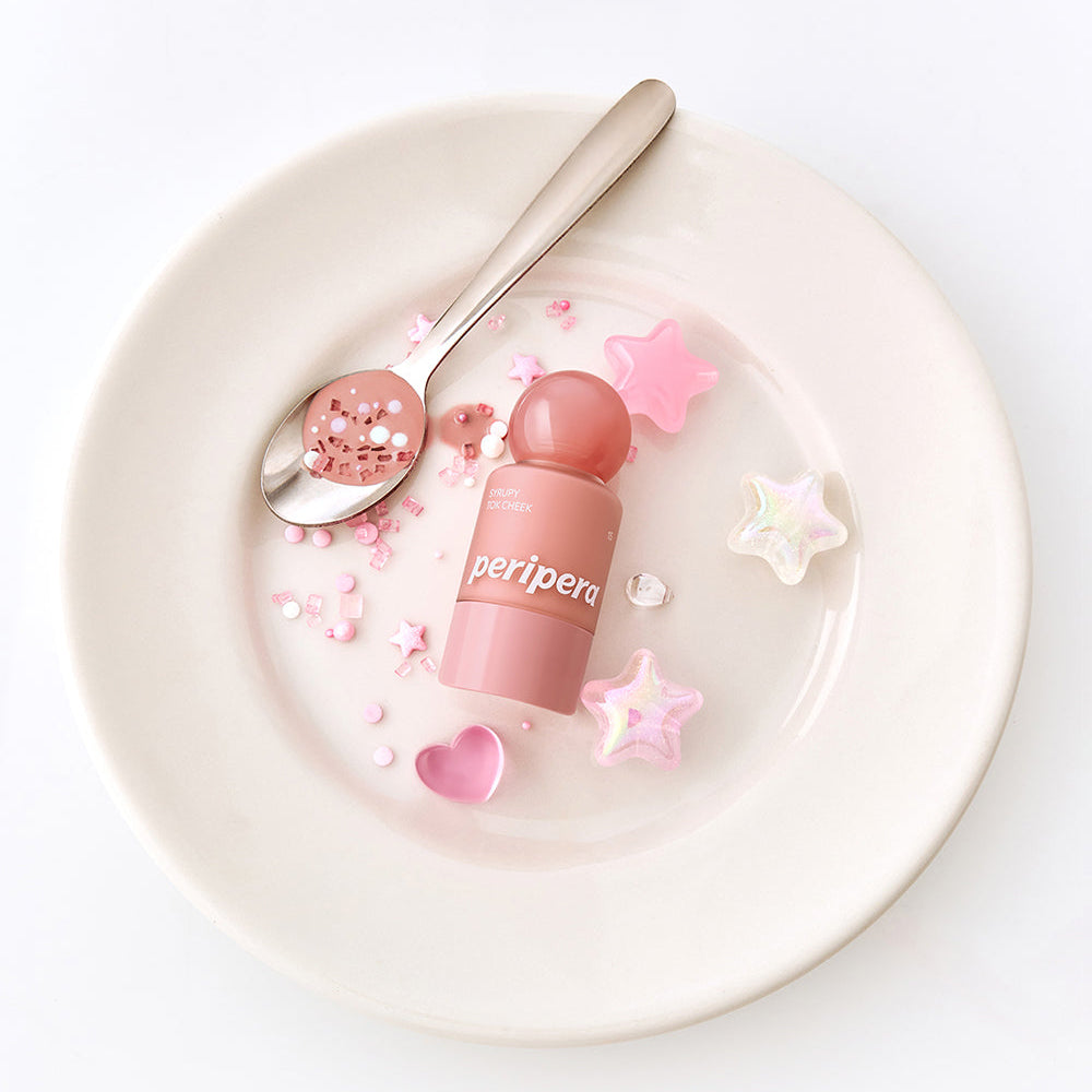 PERIPERA Syruppy Tok Cheek de la marque Peripera, packaging rose sur assiette blanche décorée d’étoiles et cœurs.