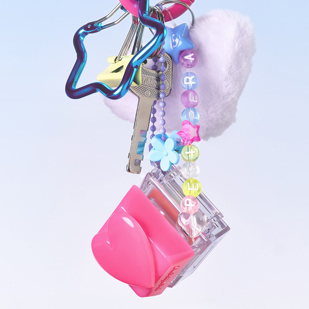 PERIPERA Talk Blush Keycap, sur porte-clés décoratif, style pop, fond clair pastel, accessoires cosmétiques.