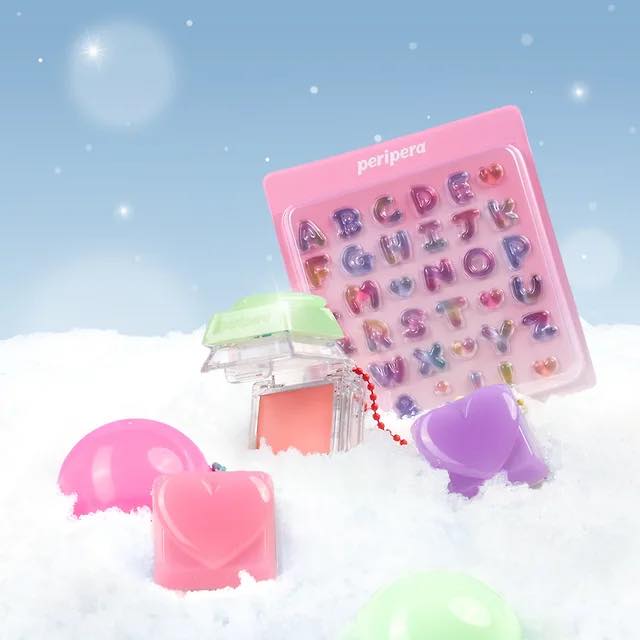 PERIPERA Talk Blush Keycap en gelée rose sur flocons enneigés, contexte visuel fun et lumineux, teintes pastel.