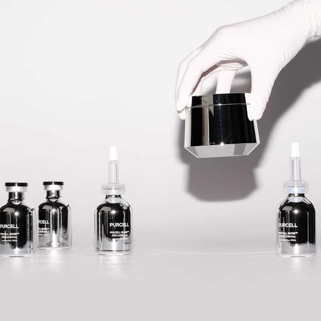 PURCELL PixelBiome™ Set (30mL of concentrate + 50mL of cream) : flacons et crème, mains gantées en studio blanc