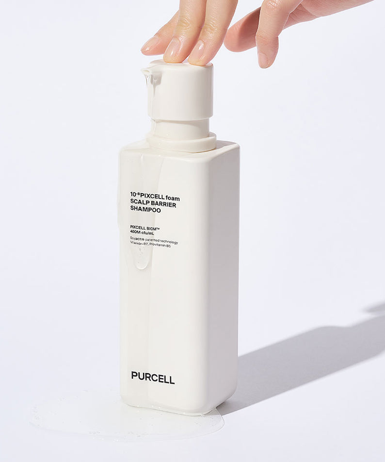 Main tenant le PURCELL Pixelform Scalp Barrier Shampoo 280ml de PURCELL, flacon blanc sur fond clair.