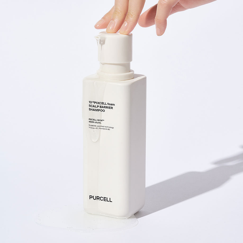 Main tenant le PURCELL Pixelform Scalp Barrier Shampoo 280ml de PURCELL, flacon blanc sur fond clair.